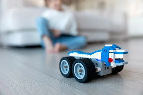 Robot made of bricks is controlled by a kid programmer, who uses tablet pc Stock Photos