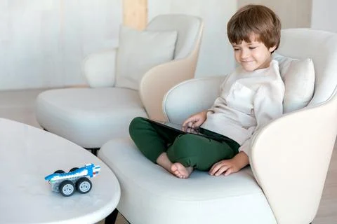 Robot made of bricks is controlled by a kid programmer, who uses tablet pc Stock Photos