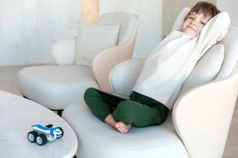 Robot made of bricks is controlled by a kid programmer, who uses tablet pc Stock Photos