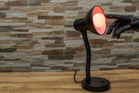 Robot or Prosthesis Hand Touching Glowing Smart Bulb in Desk Lamp Stock Photos