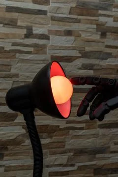 Robot or Prosthesis Hand Touching Glowing Smart Bulb in Desk Lamp Stock Photos