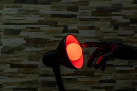 Robot or Prosthesis Hand Touching Glowing Smart Bulb in Desk Lamp Stock Photos