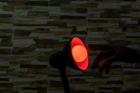 Robot or Prosthesis Hand Touching Glowing Smart Bulb in Desk Lamp Stock Photos