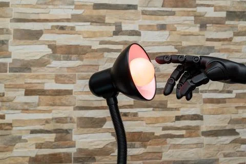 Robot or Prosthesis Hand Touching Glowing Smart Bulb in Desk Lamp Stock Photos