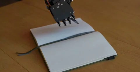 Robot With Pencil In Hand About To Write On A Notebook, Stock Footage 248090154