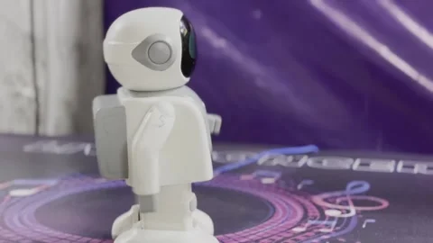 A robot is standing on a black surface with a purple background Video stock 283484688