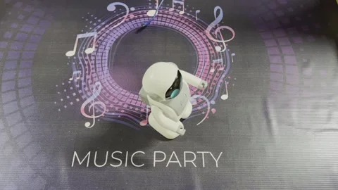 A robot is standing in front of a colorful background with musical notes 스톡 동영상 283486384