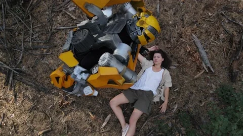 Robot transformer stands among forest next to the lying on ground girl. Stock Footage 138637212