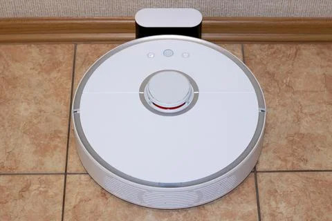 Robot vacuum cleaner on the charging dock after the finished cleaning Stock Photos