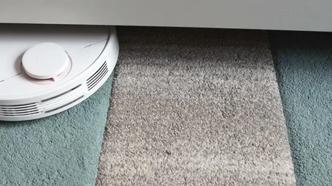 The robot vacuum cleaner circles on the carpet floor Stock Footage 166035987