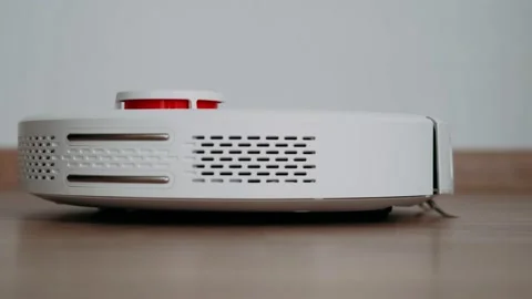 Robot vacuum cleaner cleans the floor in the room. Stock Footage 165723610