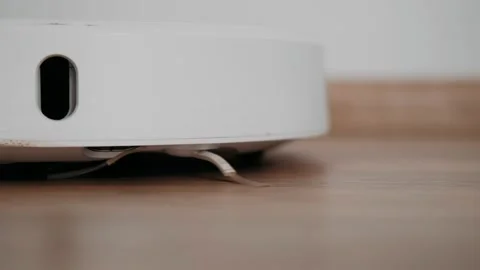 Robot vacuum cleaner cleans the floor in the room. Smart Home. Housekeeping. Stock Footage 165723681