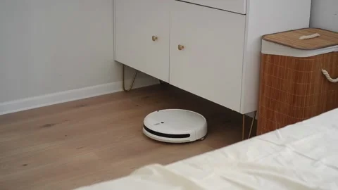 Robot vacuum cleaner cleans the floor in a bedroom Video stock 303484338