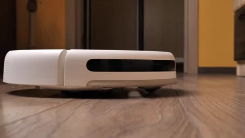 Robot vacuum cleaner cleans the room. works and rotates around its axis Video stock 254610347