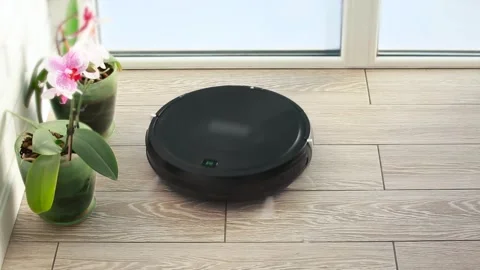 A robot vacuum cleaner does daily cleaning in an apartment Stock Footage 258206036