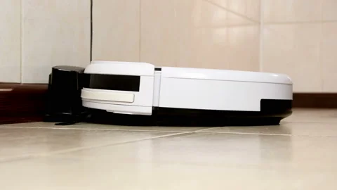Robot vacuum cleaner drives off to clean up the trash Stock Footage 108656212