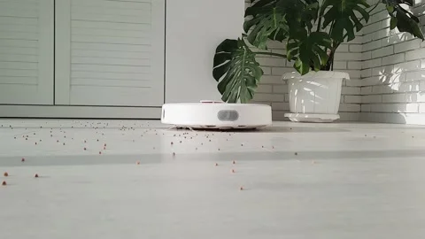 The robot vacuum cleaner drives on the laminate floor . Stock Footage 147451528