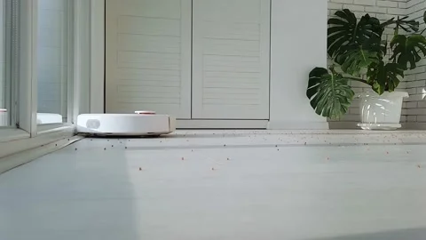 The robot vacuum cleaner drives on the laminate floor . Stock Footage 147451709