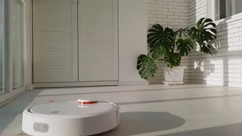The robot vacuum cleaner drives on the laminate floor Stock Footage 147451762
