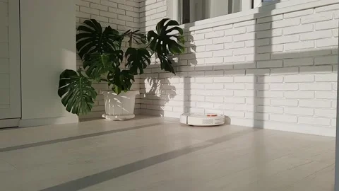 The robot vacuum cleaner drives on the laminate floor Stock Footage 147451906