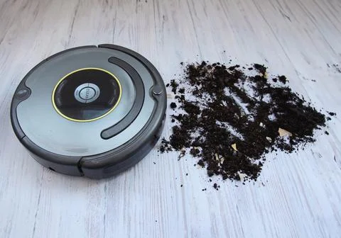 The robot vacuum cleaner effectively cleans dirty floors with a lot of debris Stock Photos