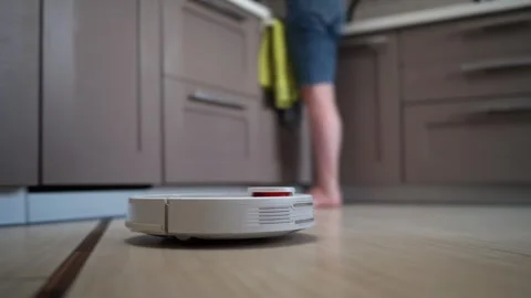 Robot Vacuum Cleaner efficiently moves and cleans tile floor. Stock Footage 333848687