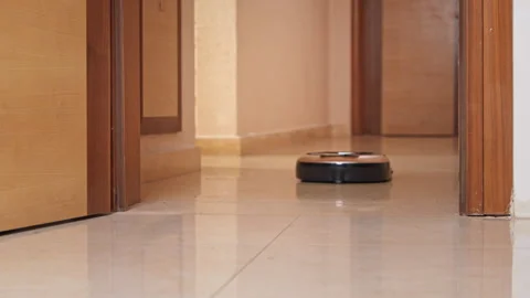 Robot vacuum cleaner moves along shiny tiled floor hallway Stock-Footage 331304653