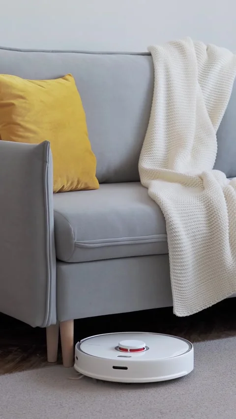 Robot vacuum cleaner moves around sofa legs Stock Footage 150216944