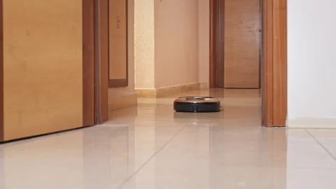 Robot vacuum cleaner moving through hallway Stock Footage 327307138