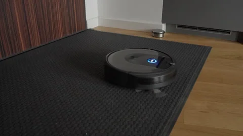 Robot vacuum cleaner performs automatic home cleaning on carpet and floor Stock Footage 329168499