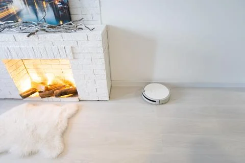 Robot vacuum cleaner performs automatic cleaning of the apartment at a certain Stock Photos