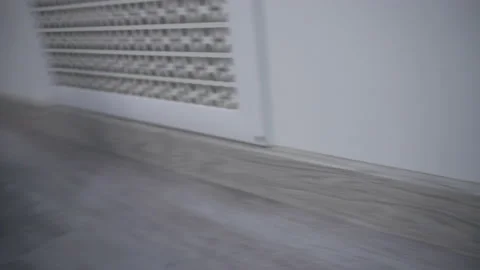 The robot vacuum cleaner rides on a white parquet floor. The robot with Stock Footage 171940833