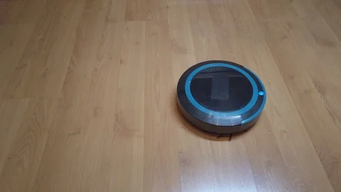 Robot vacuum cleaner rolls on laminate in the room Stock Footage 123288639