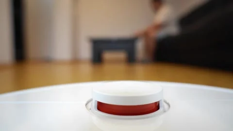 A robot vacuum cleaner start button in a modern home interior Stock Footage 321946467