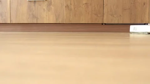 Robot vacuum cleaner washes the floor in the kitchen Stock Footage 270085460