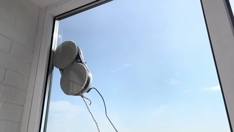 Robot vacuum cleaner washes windows with two gray microfiber attachments Stock Footage 312622741