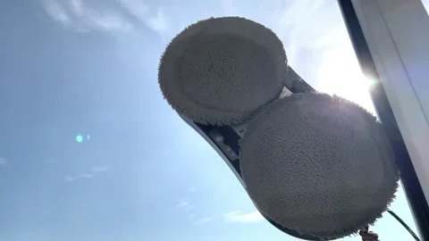 Robot vacuum cleaner washes windows with two gray microfiber attachments Stock Footage 312622742