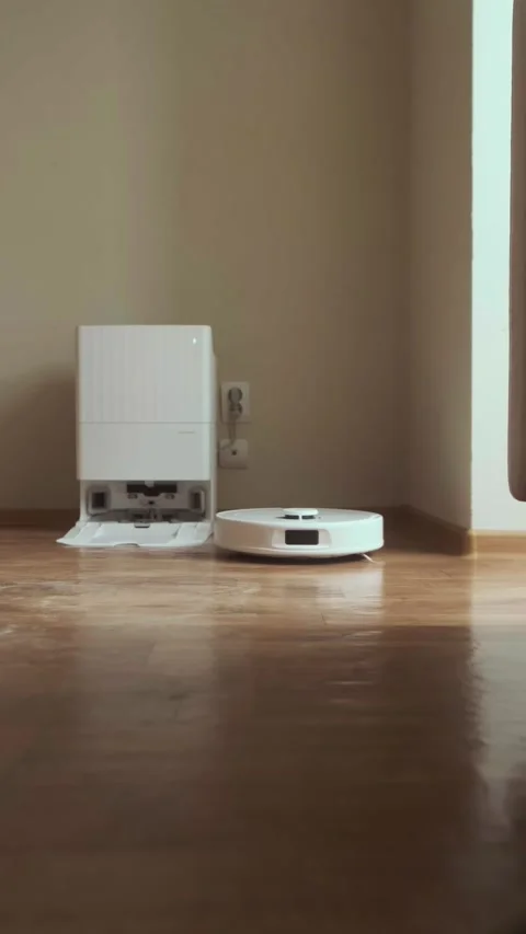 Robot vacuum cleans the floor in the room while the owner relaxes enjoying a Stock Footage 314641921