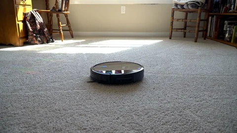 Robot Vacuum modern technology turning on and starting to clean apartment carpet Stock Footage 113973865