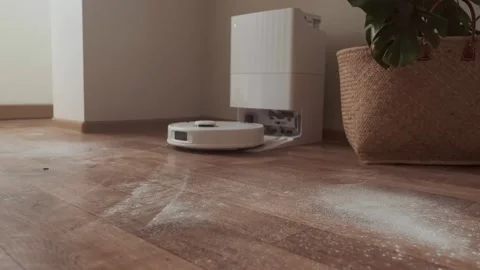 Robot vacuum receives cleaning task from owner and starts working leaving the Stock Footage 314642152