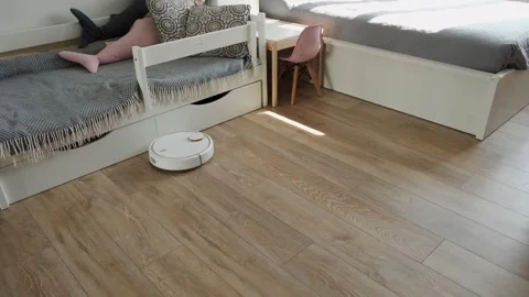 Robot vacuum sweeps and sucks the trash and dust in Stock Footage 243100506