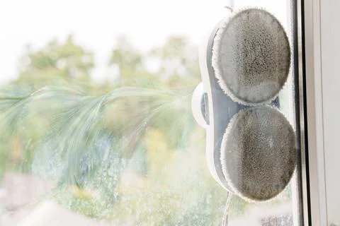 A robot window cleaner washes a window. Stock Photos