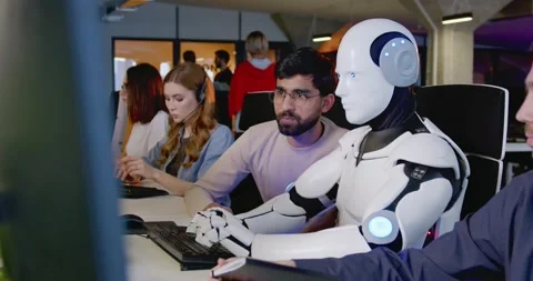 Robot working at computer and men observing. Cyborg typing on keyboard. IT team Stock Footage 179973764