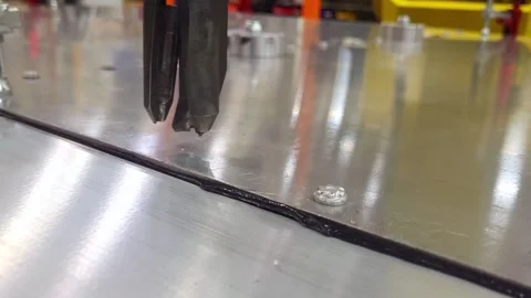 Robotic arm fixing two metal sheets with self piercing rivet in closeup Stock Footage 334647587