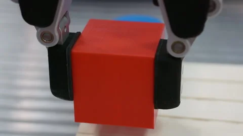 A robotic arm moves a cube-shaped part. Stock Footage 156523282