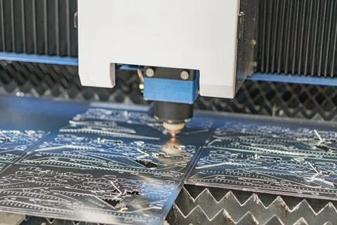 Robotic arm moving towards PCBs on an assembly line in industrial environment Stock Photos