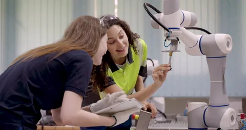 Robotic arm operating during training session with female technicians Stock Footage 319476996