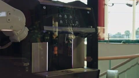 Robotic arm operating modern coffee machine beside bright cafe window, preparing Stock Footage 344995362