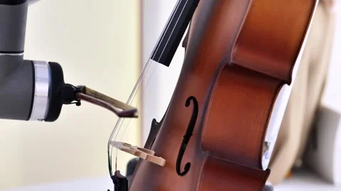 Robotic arm performing music on a cello, blending artificial intelligence and Stock Footage 321348376
