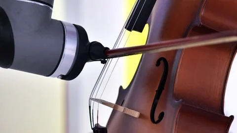 Robotic arm playing classical cello music at technology art exhibition Video stock 322029255